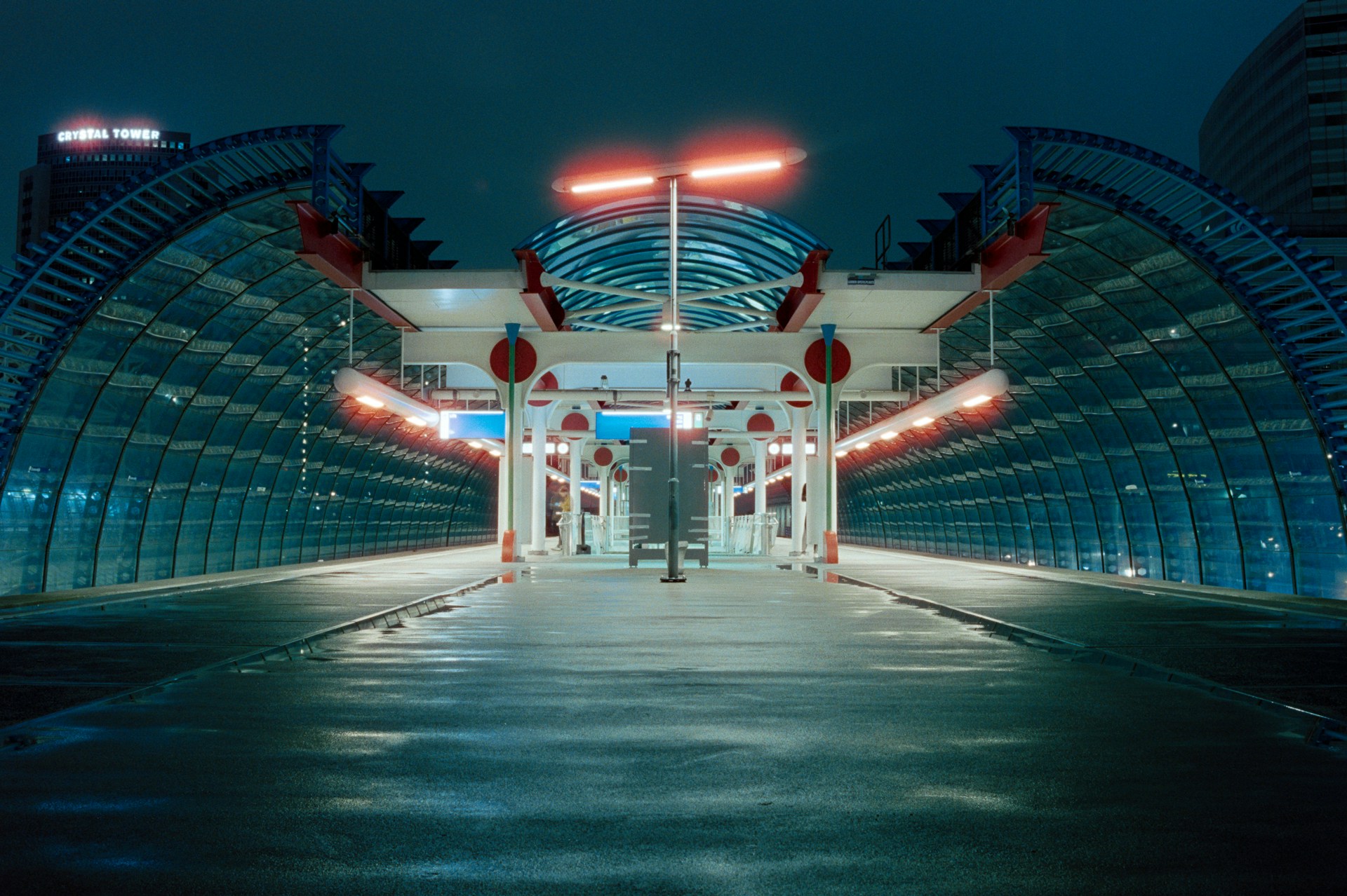 a very long and empty walkway with lights at night