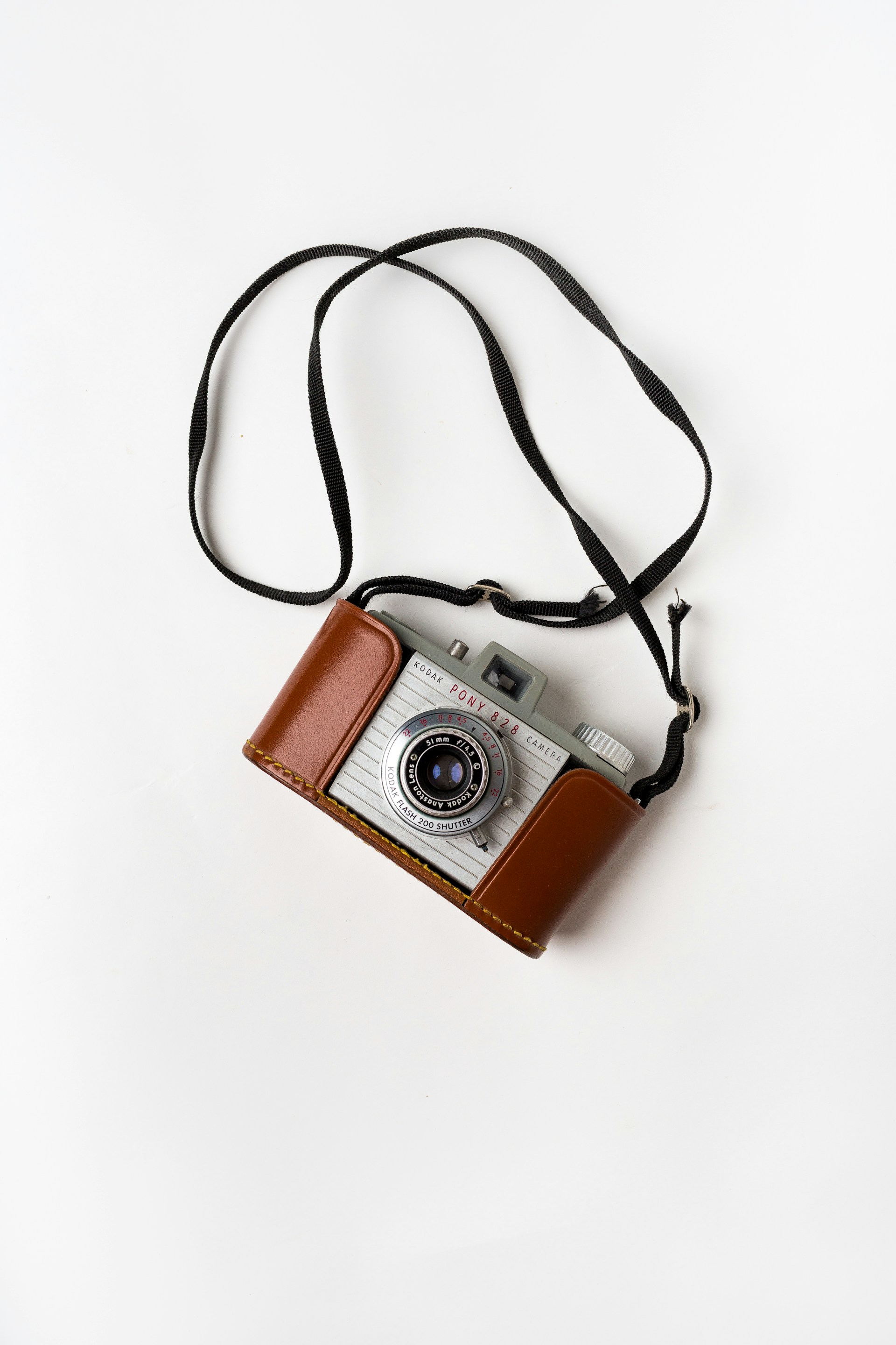 a photo of a old kodak film camera with a leather case 