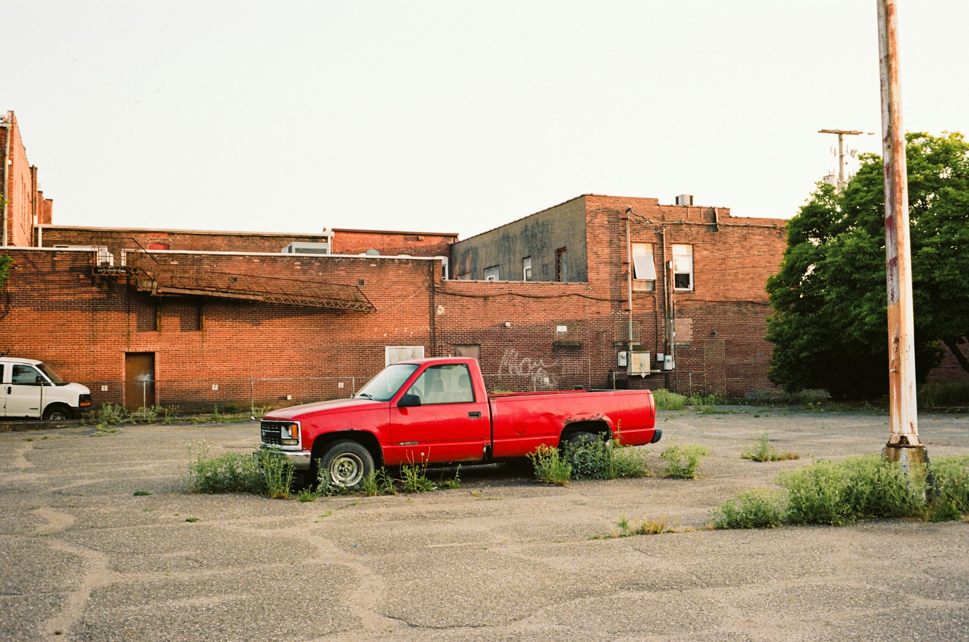 a red pick up truck parked in a parking lot shot with a kodak portra 400 35mm film 