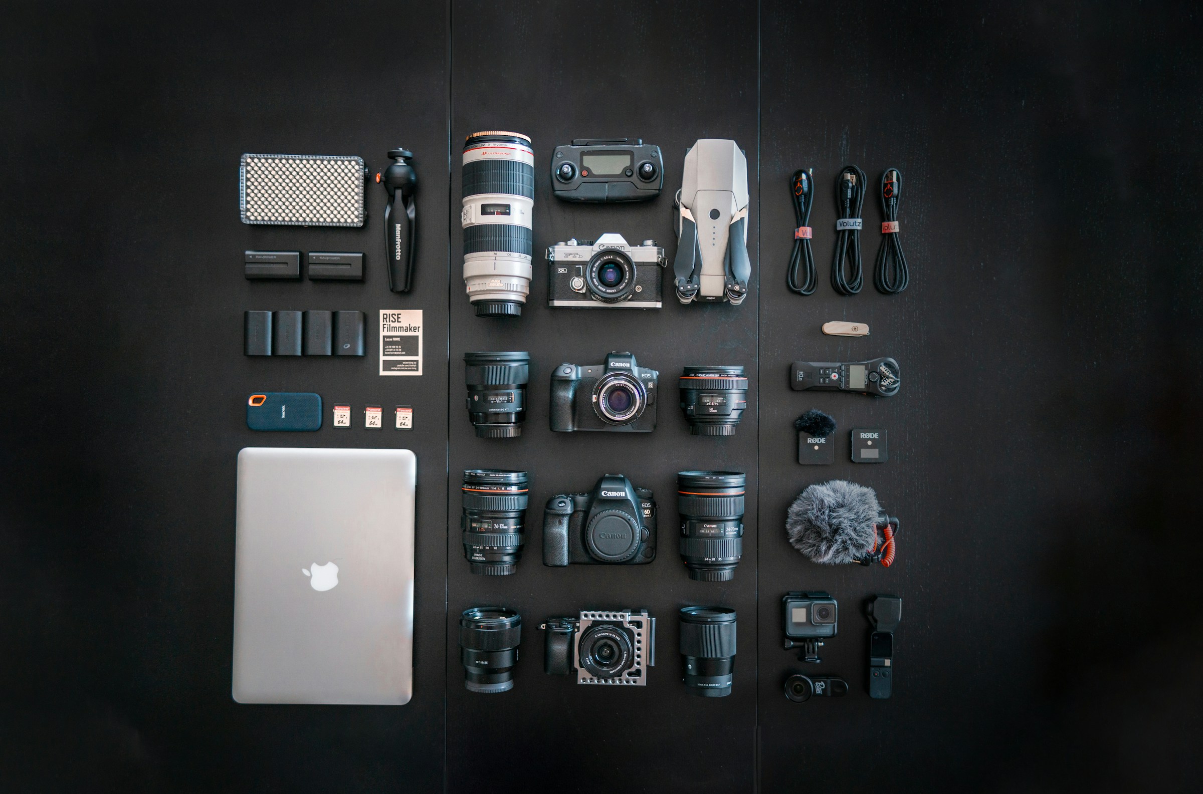 silver macbook black-dslr camera and black dslr camera